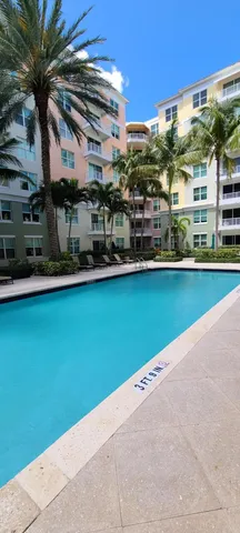 a view of a swimming pool with a lawn chairs under an umbrella