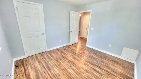 a view of empty room with wooden floor