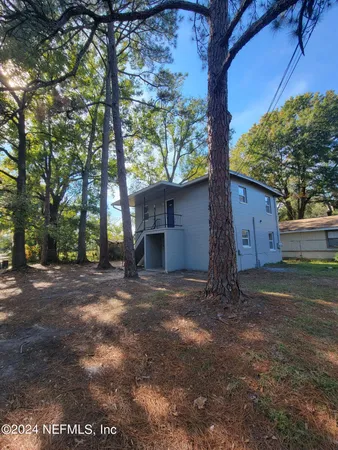 a view of a house with a yard and tree