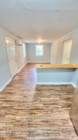 a view of empty room with wooden floor