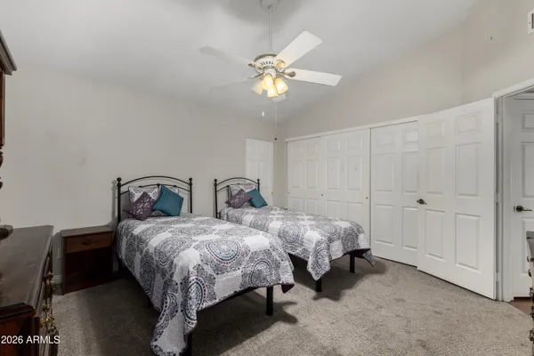 a bed room with two beds and a ceiling fan