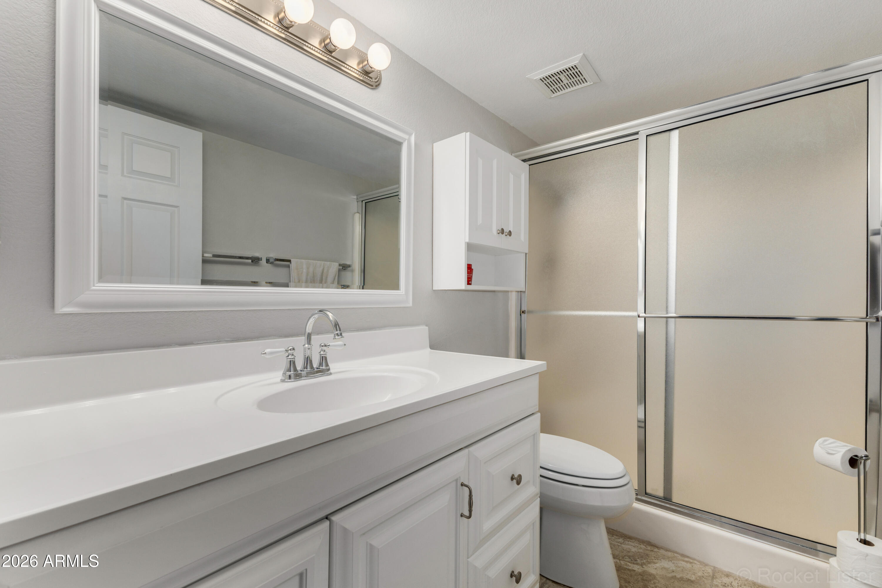 542 South Higley Road, Unit 61 Mesa, AZ 85206 - Photo 18 of 33 a bathroom with a sink a mirror a toilet and shower