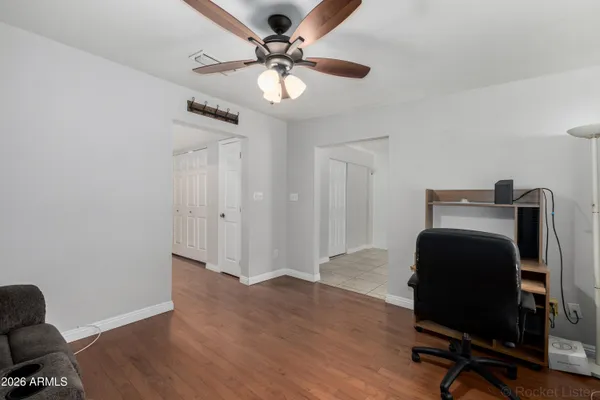 a workspace with wooden floor and a ceiling fan