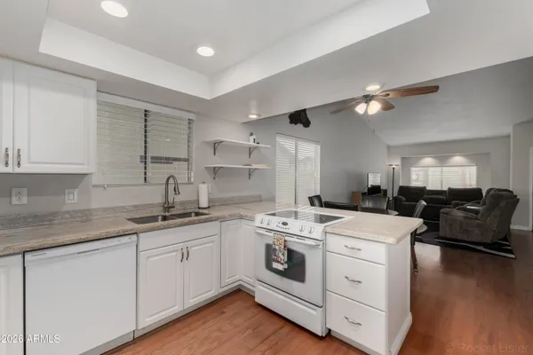 a kitchen that has a lot of cabinets in it and wooden floors