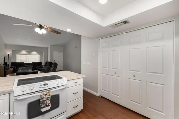 a kitchen with a stove and a view of living room