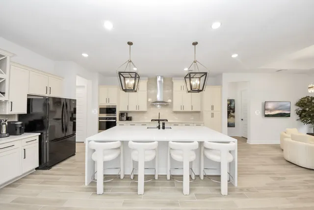 a kitchen with a dining table chairs stainless steel appliances and cabinets