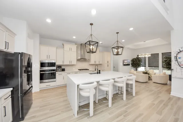 a large white kitchen with a large window and white appliances