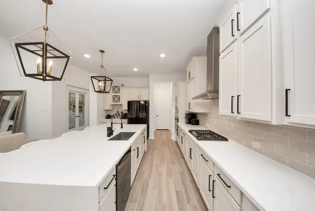 a kitchen with a sink a chandelier and chairs