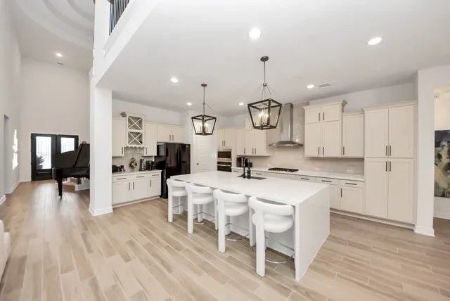 a kitchen with a dining table chairs stainless steel appliances and cabinets