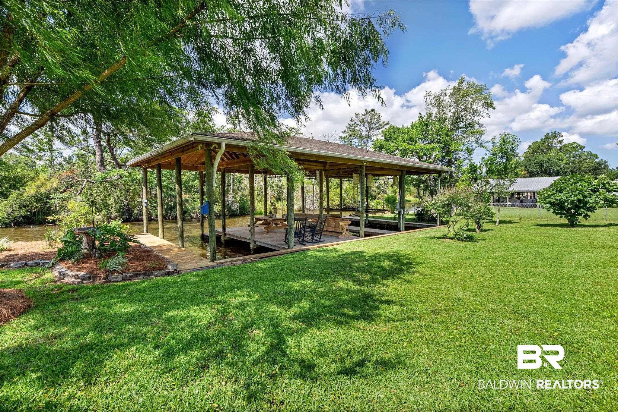 3801 Point Road Mobile, AL 36619 - Photo 36 of 55 Covered boat dock with multiple slips, wooden decking, and direct water access
