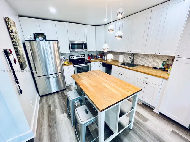 a kitchen with stainless steel appliances refrigerator stove microwave and cabinets