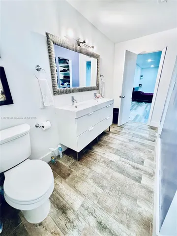 a bathroom with a toilet sink and mirror