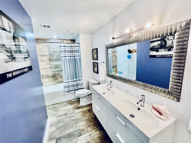 a bathroom with a bathtub sink and mirror