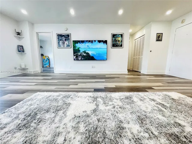 a view of a livingroom with wooden floor and a flat screen tv