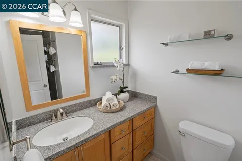 a bathroom with a granite countertop sink and a mirror