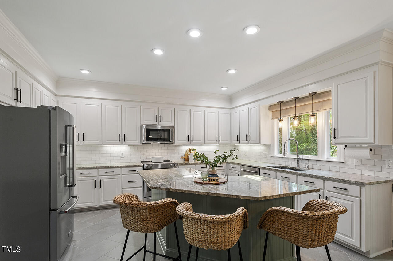 2520 Harptree Court Raleigh, NC 27613 - Photo 19 of 69 a kitchen with granite countertop a sink a stove a refrigerator a dining table and chairs