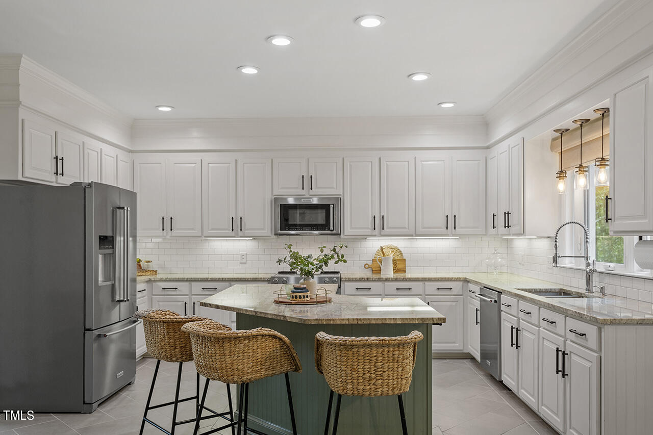 2520 Harptree Court Raleigh, NC 27613 - Photo 25 of 69 a kitchen with stainless steel appliances granite countertop a stove a sink a refrigerator and white cabinets