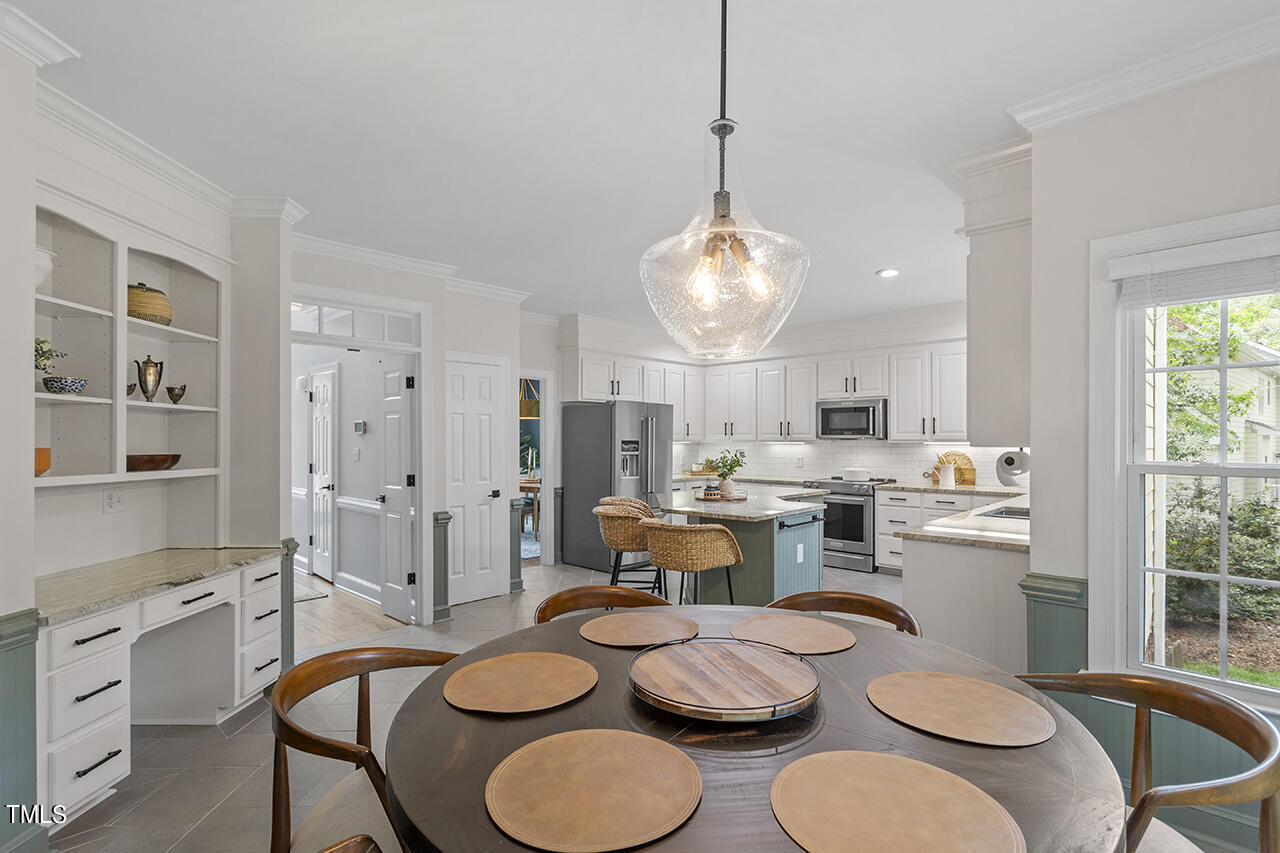 2520 Harptree Court Raleigh, NC 27613 - Photo 26 of 69 a kitchen with a dining table and chairs