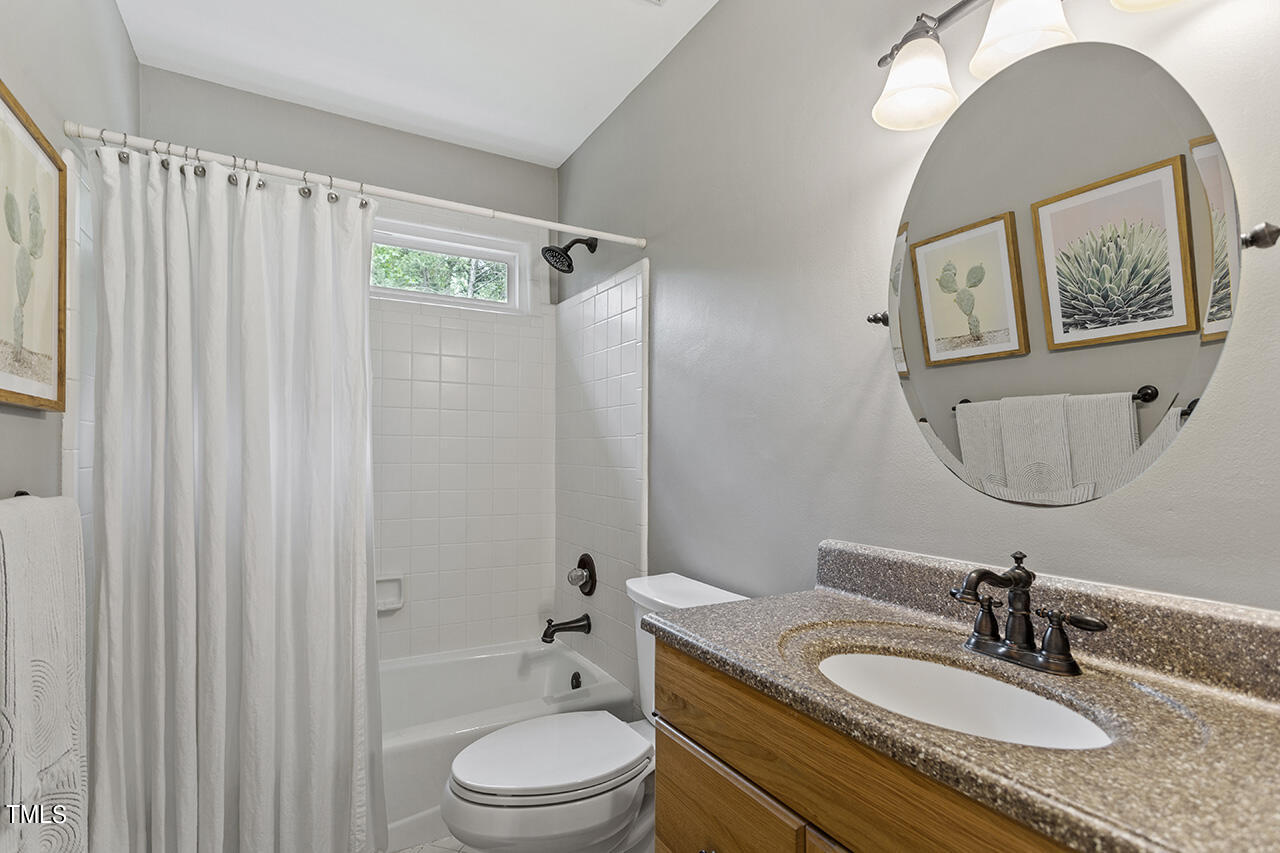 2520 Harptree Court Raleigh, NC 27613 - Photo 39 of 69 a bathroom with a granite countertop sink mirror toilet and bathtub