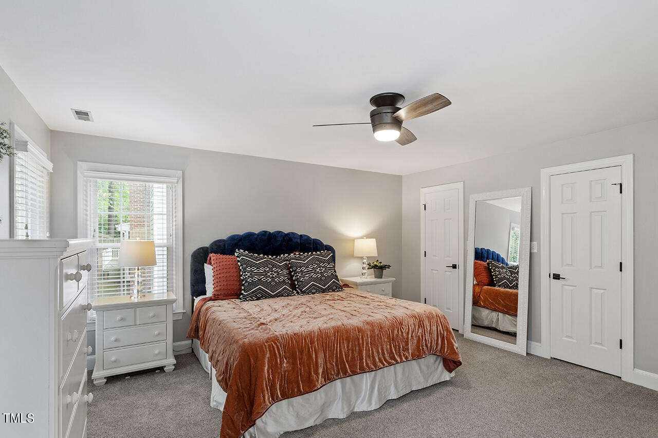 2520 Harptree Court Raleigh, NC 27613 - Photo 41 of 69 a bedroom with a bed and a chandelier