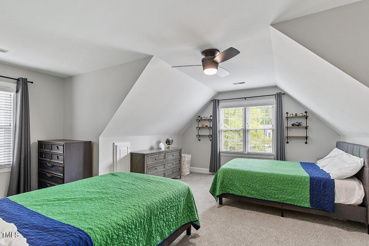 2520 Harptree Court Raleigh, NC 27613 - Photo 45 of 69 a bedroom with a bed a mirror on dresser and a window