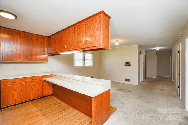 a view of a kitchen with stainless steel appliances granite countertop a sink and cabinets