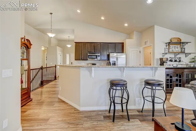 a living room with furniture kitchen view and a window