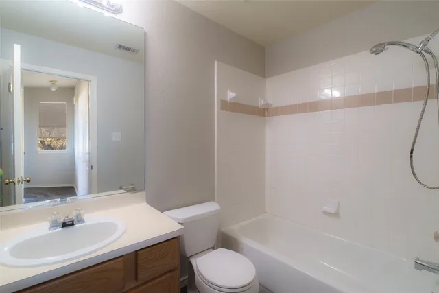 a bathroom with a sink toilet vanity and shower