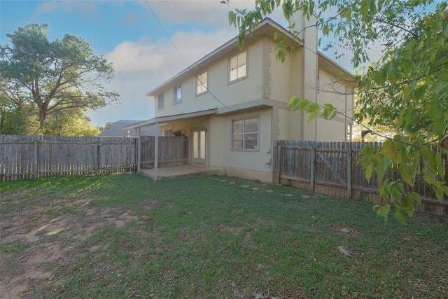 a view of a house with backyard and a tree