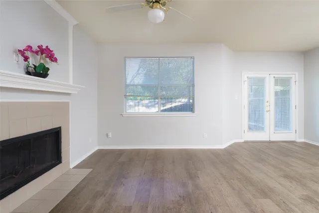 a view of an empty room with a window and a fireplace