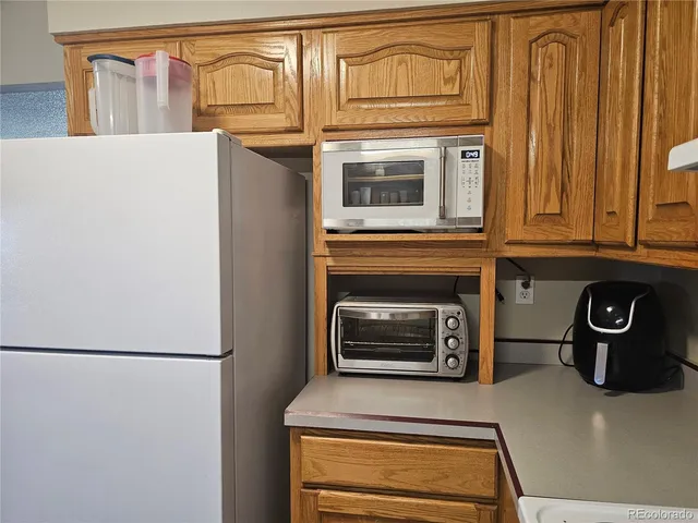 a kitchen with stainless steel appliances granite countertop a refrigerator and a stove top oven