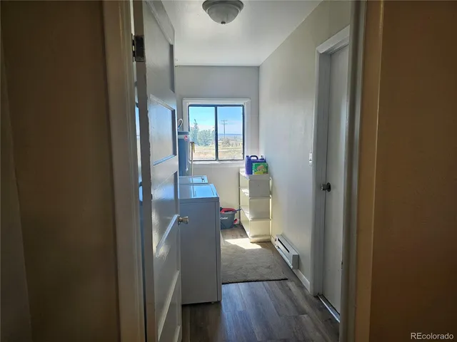 a view of hallway with furniture and wooden floor