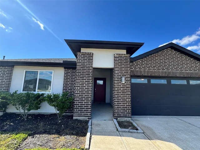 a front view of a house with glass windows and garage