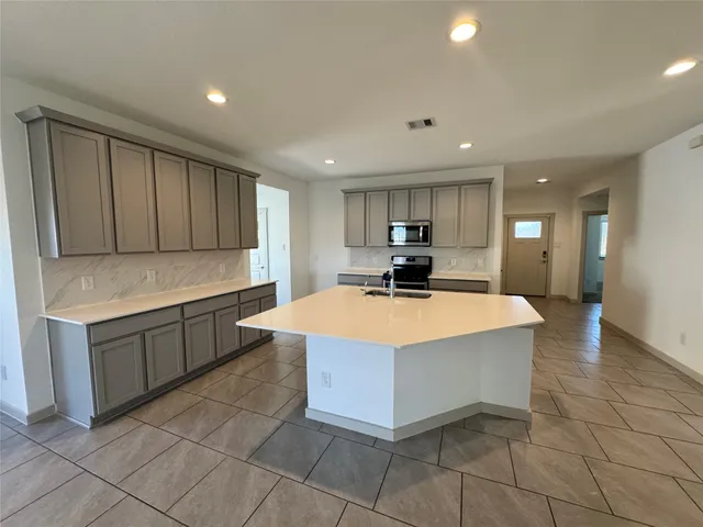 a kitchen with a sink a counter top space cabinets and stainless steel appliances