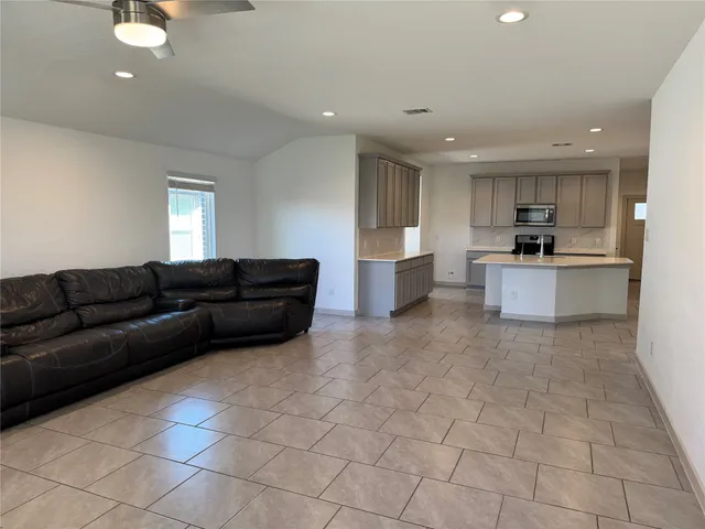 a living room with a couch and a view of kitchen counter top space