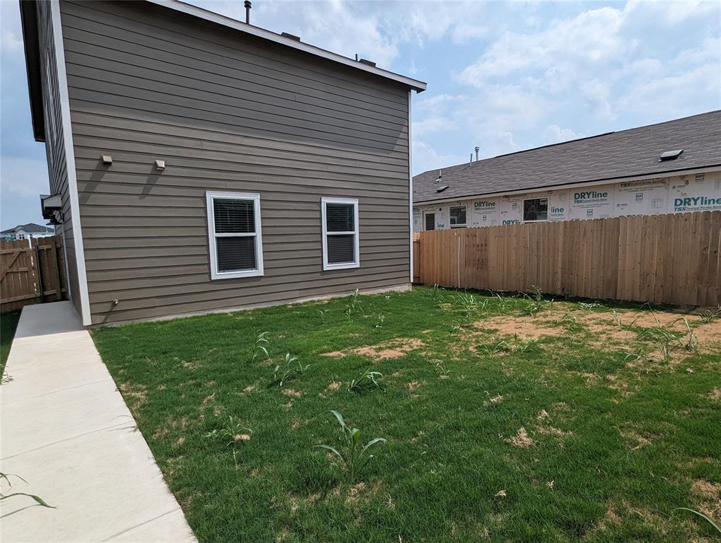 152 Avre Loop Kyle, TX 78640 - Photo 22 of 24 A well-maintained side yard with a sturdy wooden fence providing privacy.