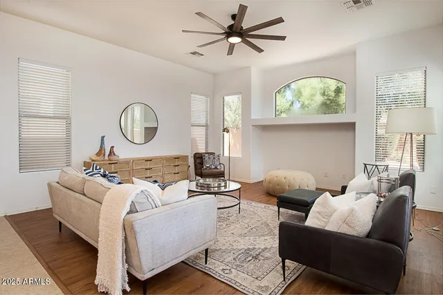 a living room with furniture a large window and a potted plant