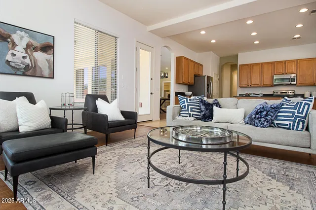 a living room with furniture and a dining table with wooden floor