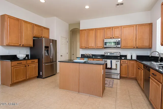 a kitchen with stainless steel appliances granite countertop a refrigerator stove top oven a sink and dishwasher