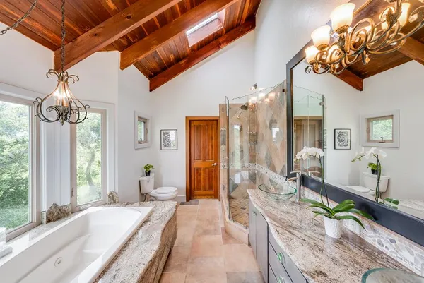 a bathroom with a granite countertop sink and a large mirror