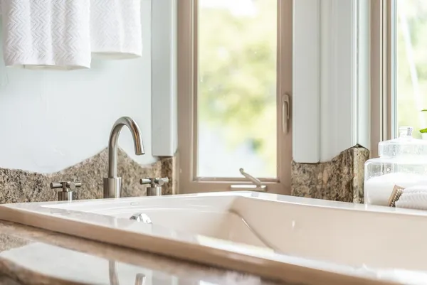 a bathroom with a granite countertop sink toilet a mirror and shower