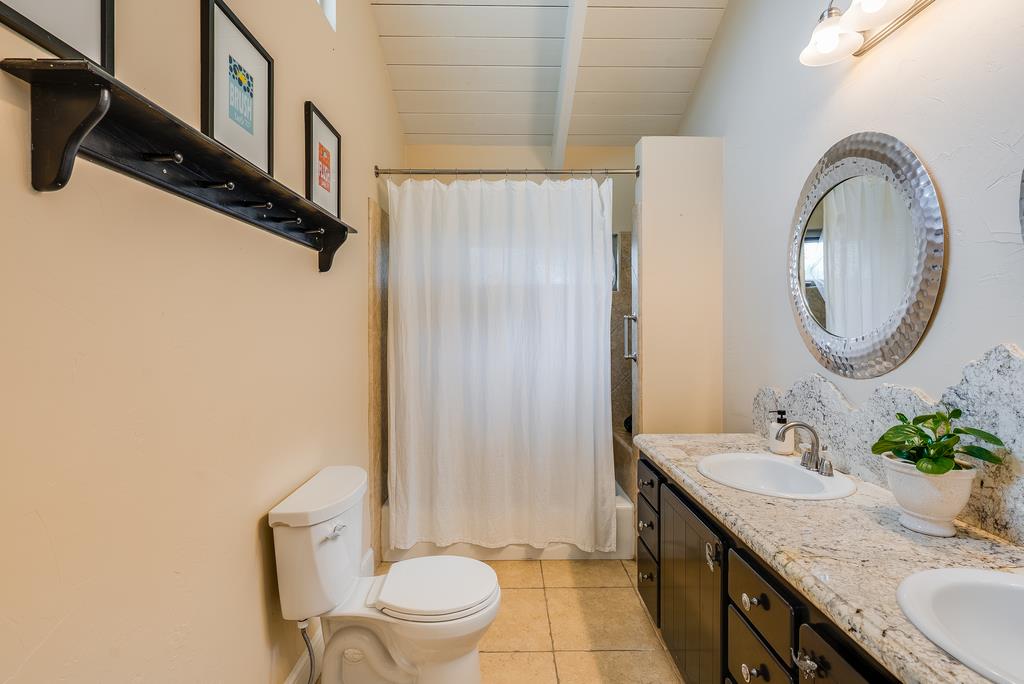 1501 Hidden Valley Road Soquel, CA 95073 - Photo 33 of 61 a bathroom with a granite countertop sink toilet a mirror and shower