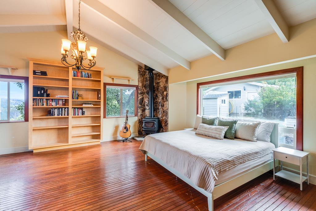 1501 Hidden Valley Road Soquel, CA 95073 - Photo 47 of 61 a bedroom with a large bed a chandelier and windows