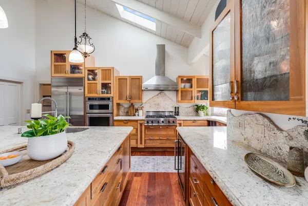 a kitchen with stainless steel appliances granite countertop a stove and a refrigerator