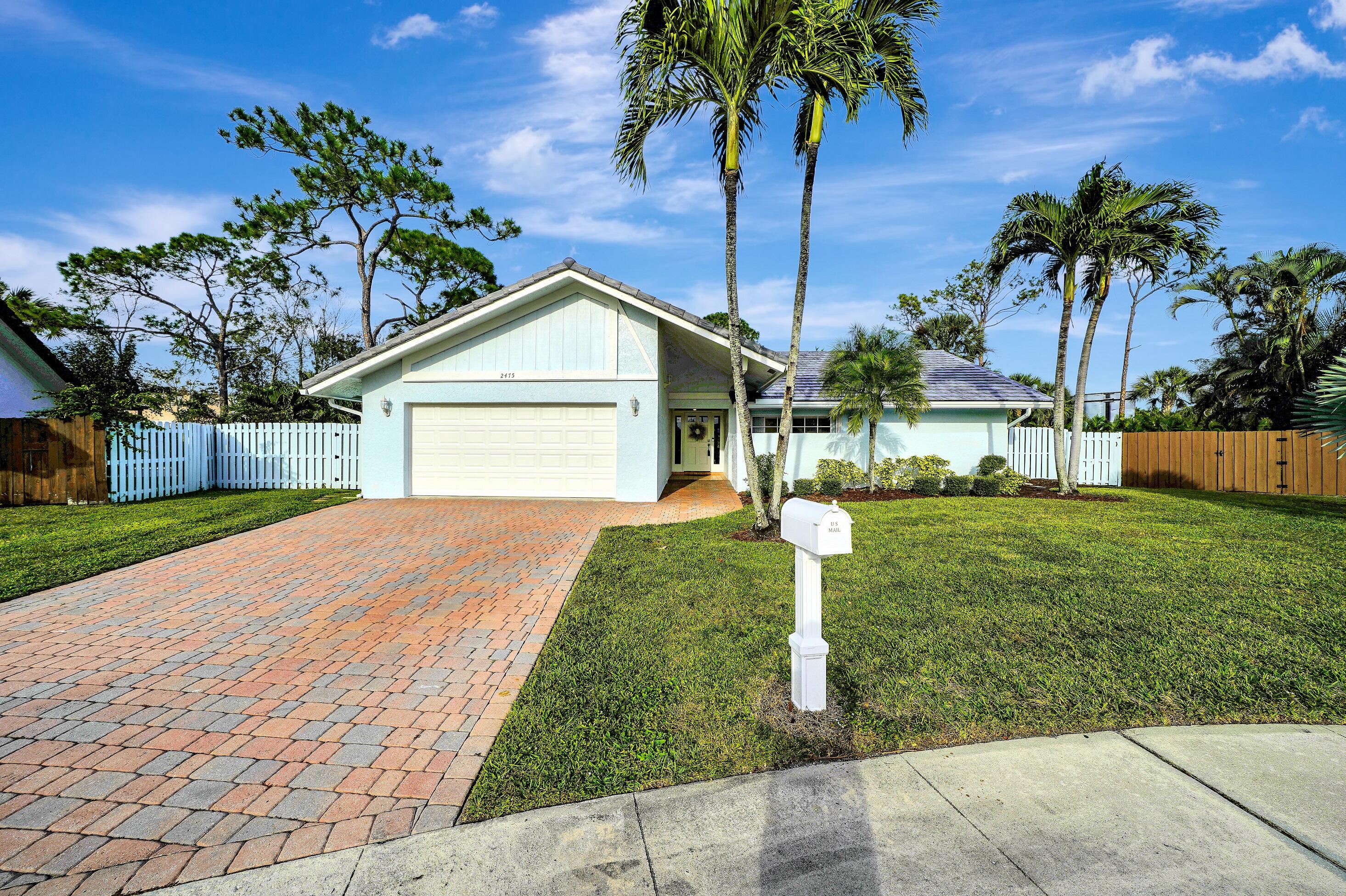 2475 Northwest 25th Street Boca Raton, FL 33431 - Photo 1 of 72 a front view of a house with a yard and palm trees