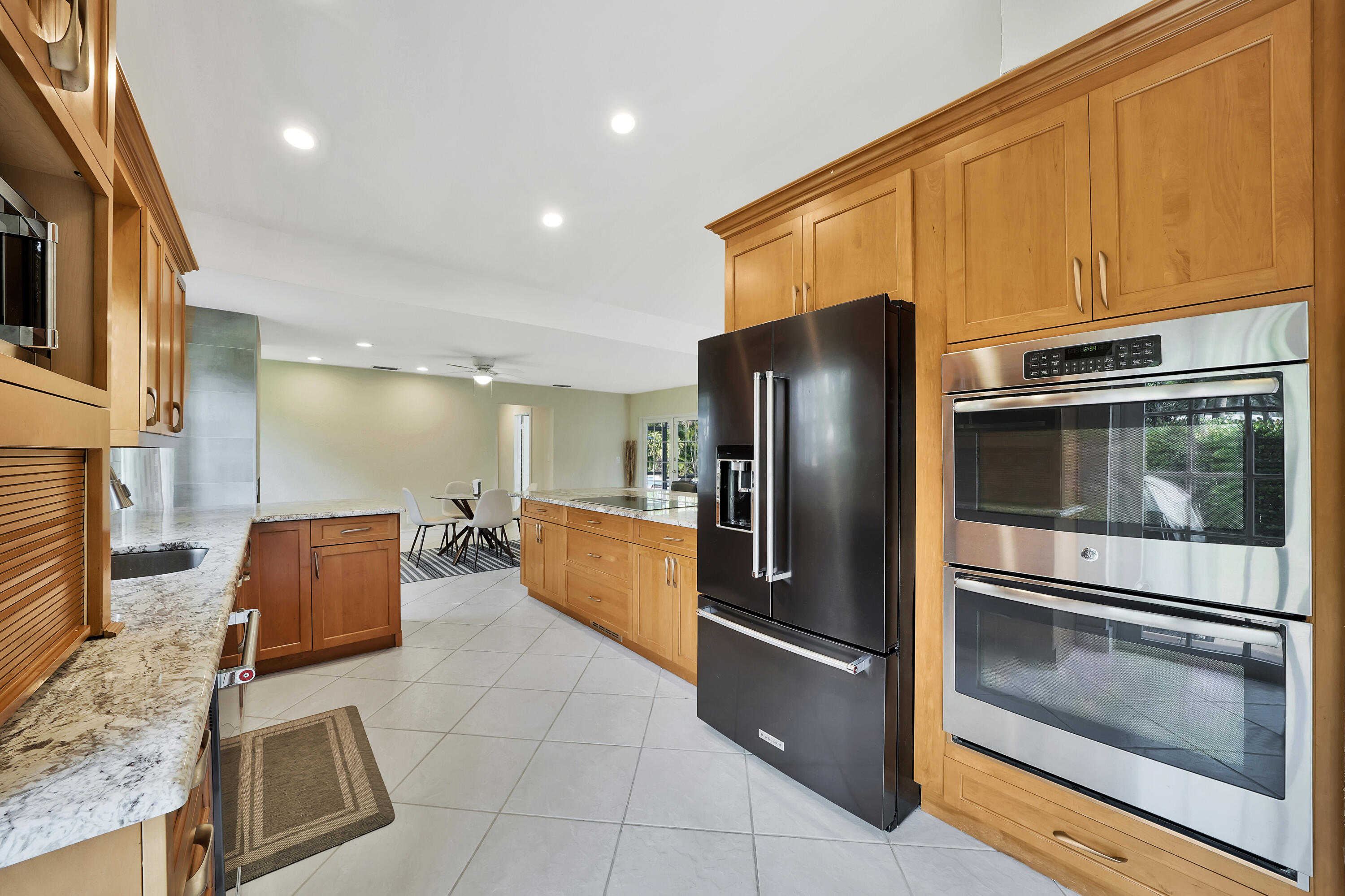 2475 Northwest 25th Street Boca Raton, FL 33431 - Photo 13 of 72 a kitchen with stainless steel appliances granite countertop a refrigerator and a stove top oven