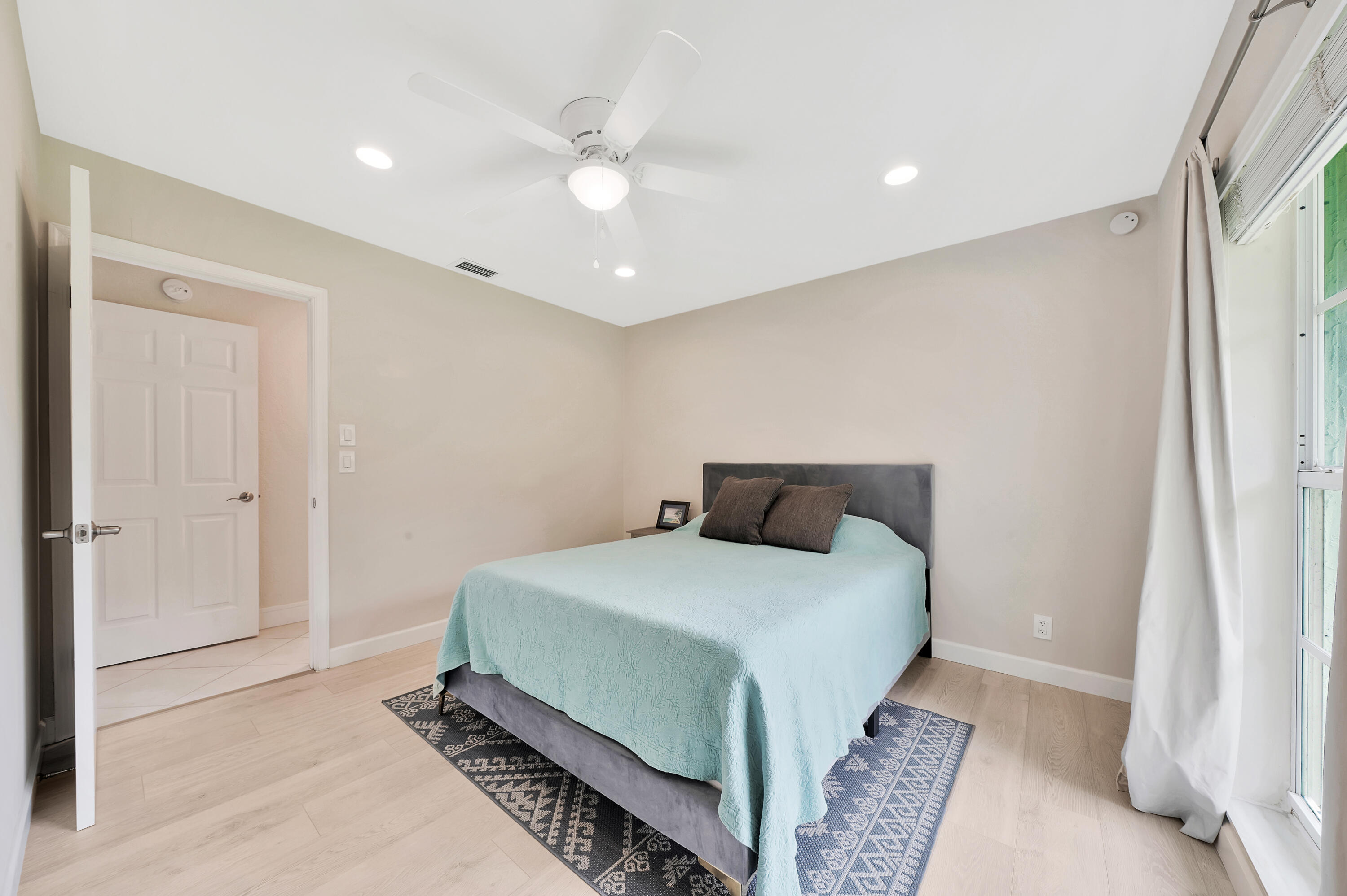 2475 Northwest 25th Street Boca Raton, FL 33431 - Photo 42 of 72 a bedroom with a bed and a chandelier