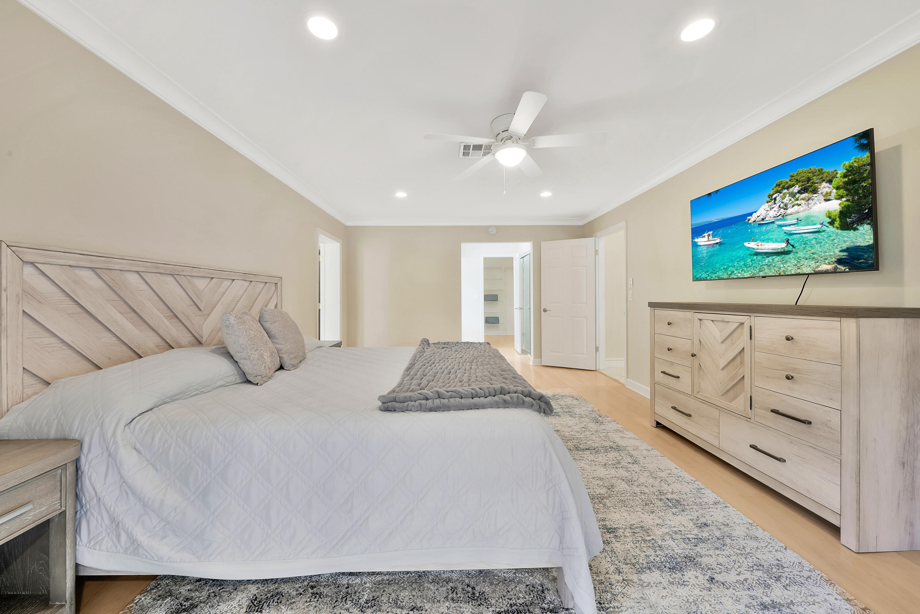 2475 Northwest 25th Street Boca Raton, FL 33431 - Photo 46 of 72 a spacious bedroom with a bed a painting on the wall and a flat screen tv