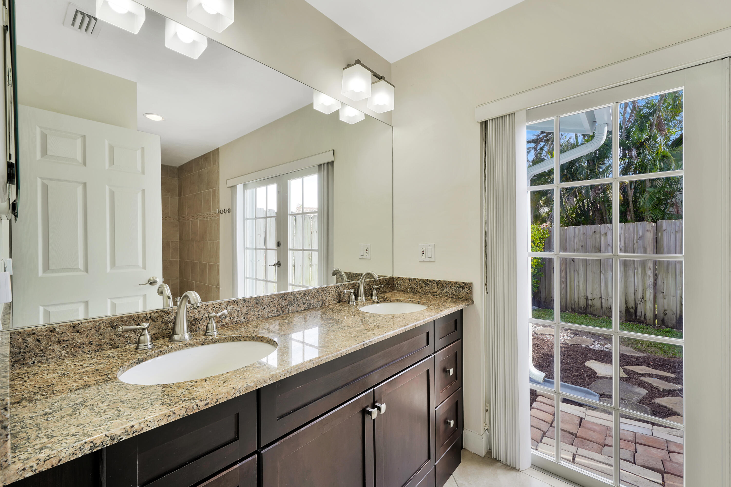 2475 Northwest 25th Street Boca Raton, FL 33431 - Photo 56 of 72 a bathroom with a granite countertop sink and a mirror