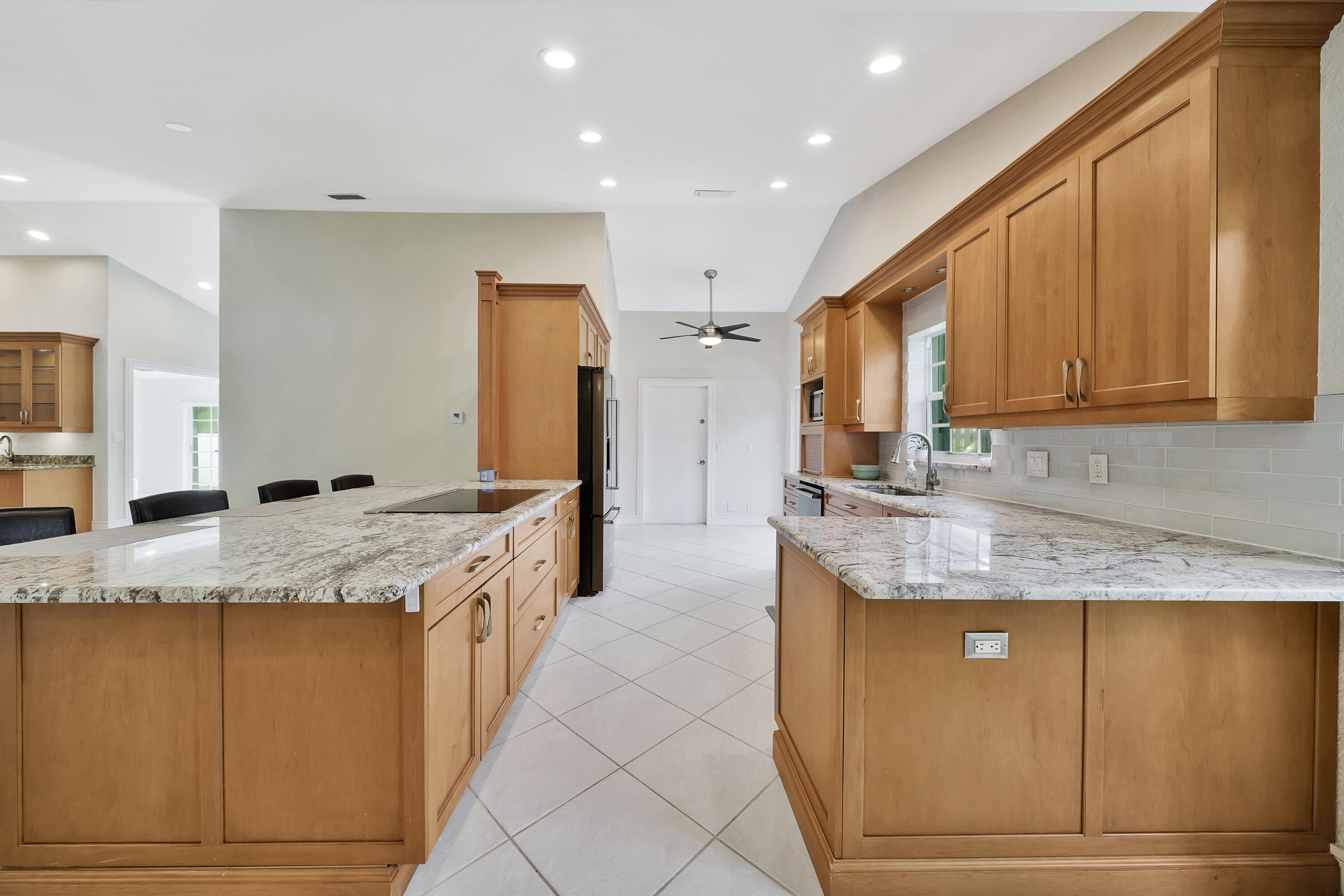 2475 Northwest 25th Street Boca Raton, FL 33431 - Photo 7 of 72 a kitchen with granite countertop cabinets sink and stainless steel appliances